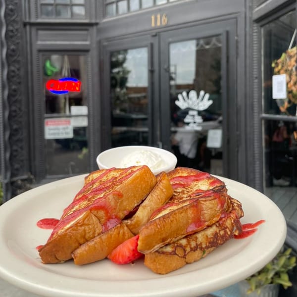 Strawberry French toast with whipped cream on a plate outside Water Street Waffle Co.
