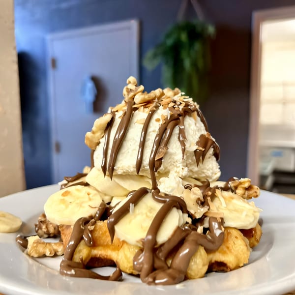 Water Street Waffle Co. waffle topped with bananas, walnuts, ice cream, and chocolate drizzle.