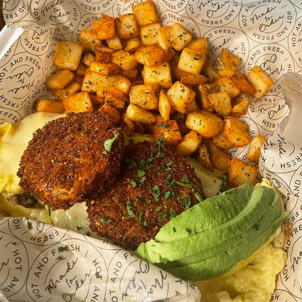 Water Street Waffle Co.'s breakfast with crispy fried chicken, avocado, scrambled eggs, and seasoned home fries.